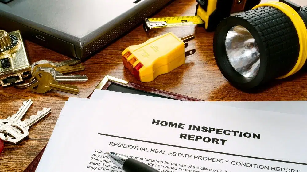 Home inspection report with inspector tools around it.