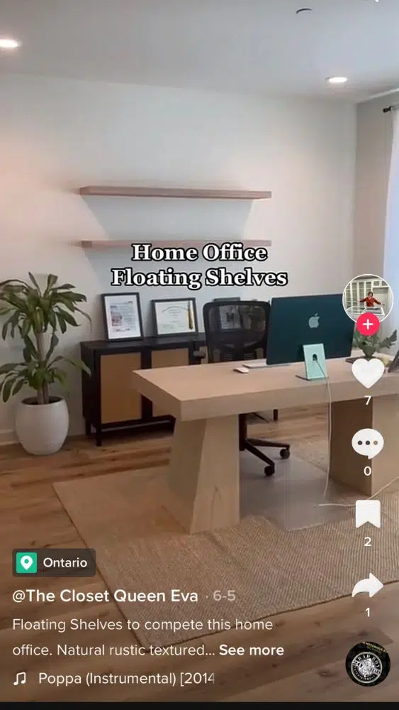 Screenshot of @theclosetqueeneva's TikTok video showing a modern office with chunky floating shelves on the back wall.