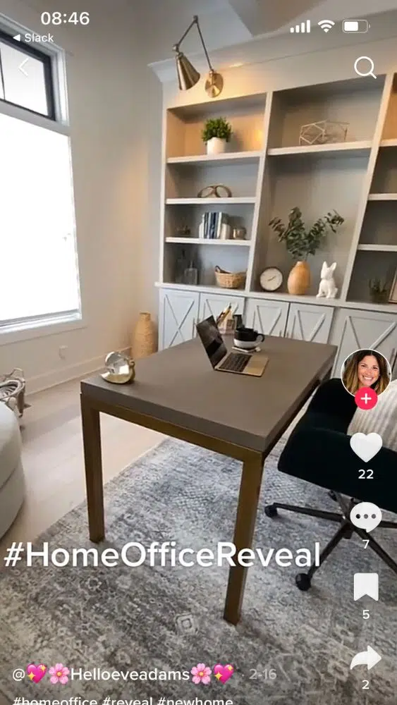 Screenshot of @helloeveadams' TikTok video showing a home office with a light grey built-in. Gold table lamp style sconces hang from the top of the built-in.