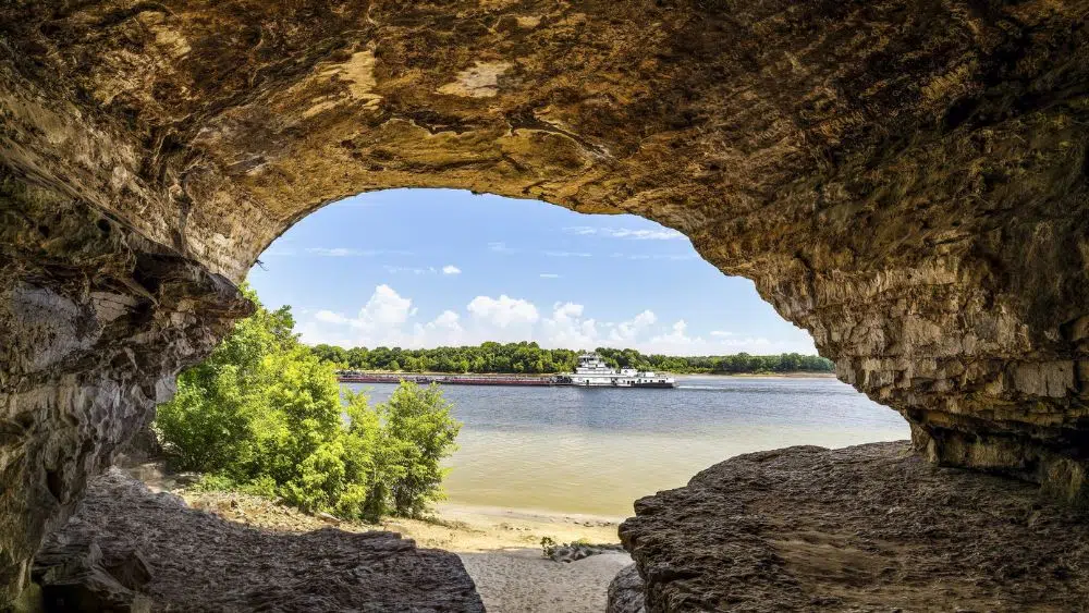 View from inside a cave looking out over a river.