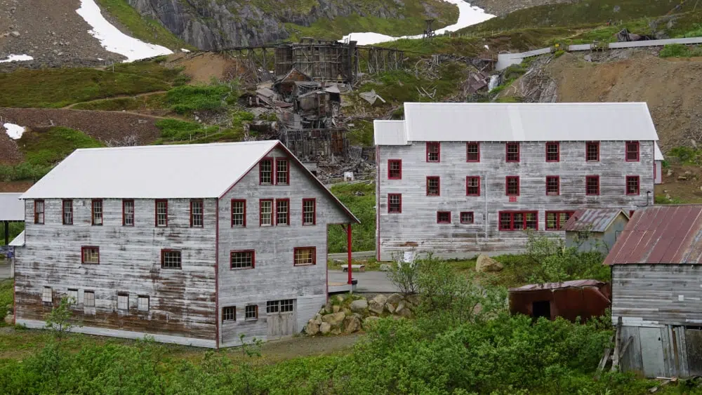 View of three-story white-washed buildings at Independence Mine Historical Park in Alaska