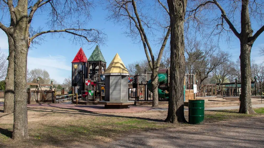 A park playground with colorful towers and decorated with painted medieval shields.