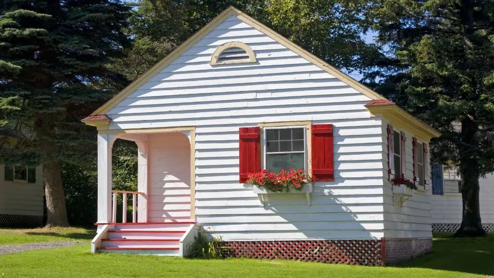 pink and white tiny home with flowerbed in window illinios