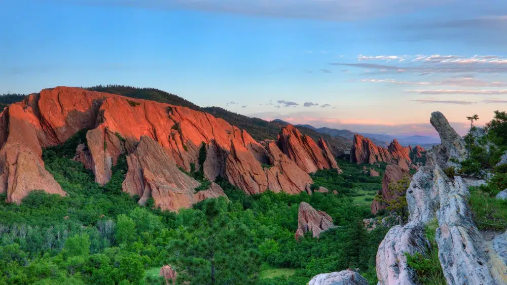 View of red cliffs and green trees at Roxborough State Park, Colorado.