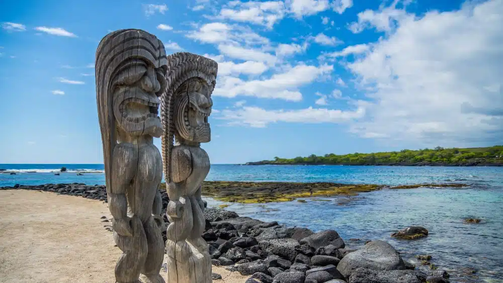 Two traditional Hawaiian wood carvings along shoreline at Puuhonoa o Honaunau National Historic Park on the Big Island of Hawaii