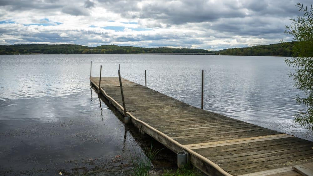 A wooden pier leading out to a lake.
