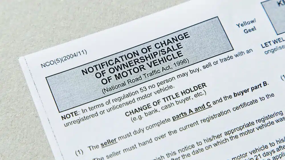 Paperwork that reads "Notification of change of ownership/sale of motor vehicle" across the top.