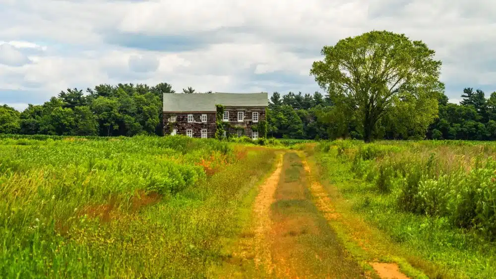 Large historic colonial-style house in a grassy field.
