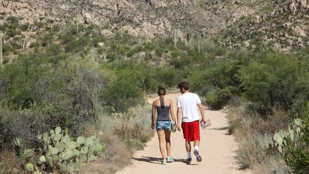 A young woman and man hike on a trail in Catalina State Park near Oro Valley, Arizona