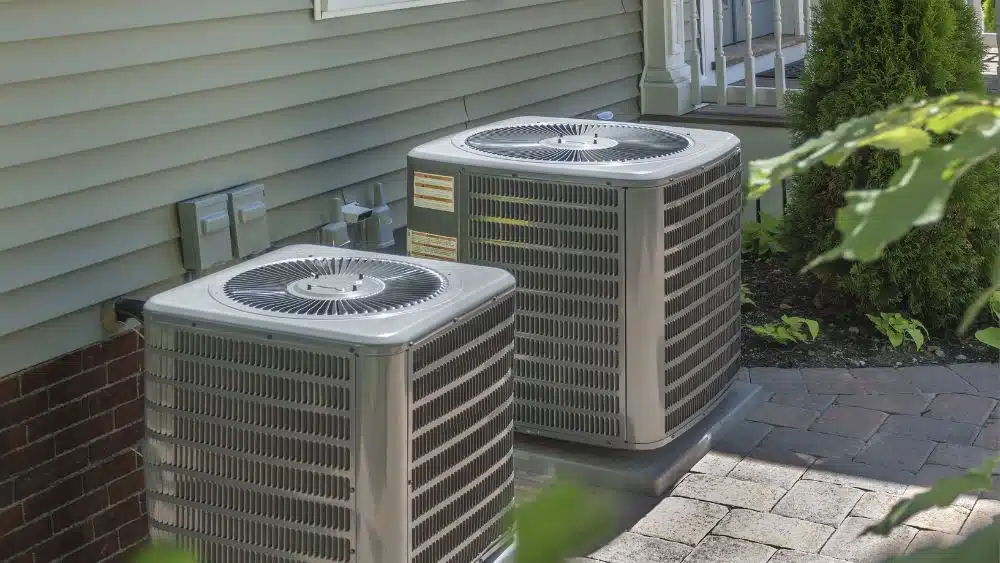 Two AC units outside of a house.