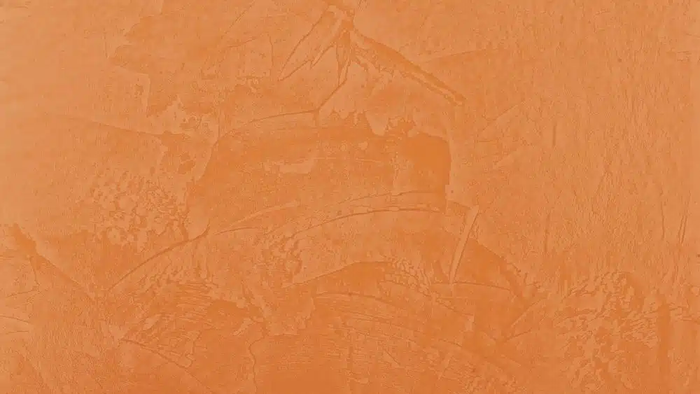 Orange wall with a texture that looks like it was painted unevenly with a paint spatula.