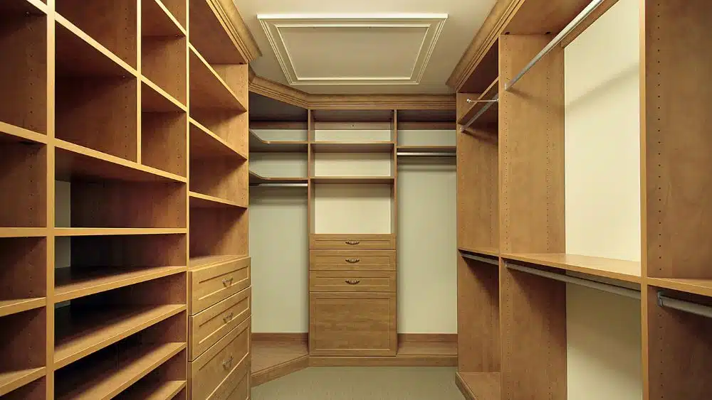Walk-in closet with wooden shelves that extend to the ceiling.