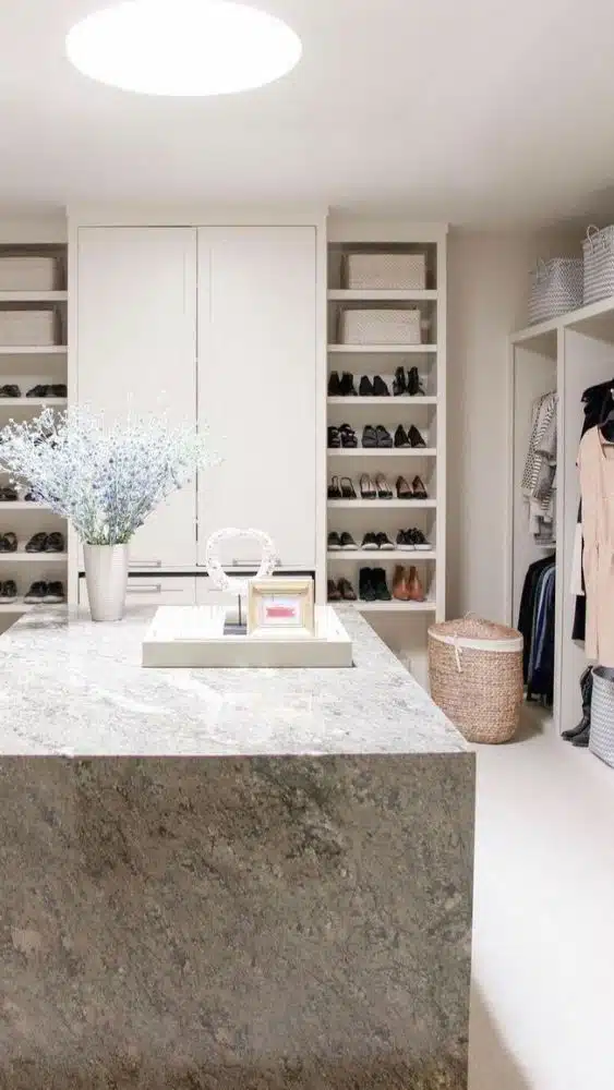 Walk-in closet with a large marble island.