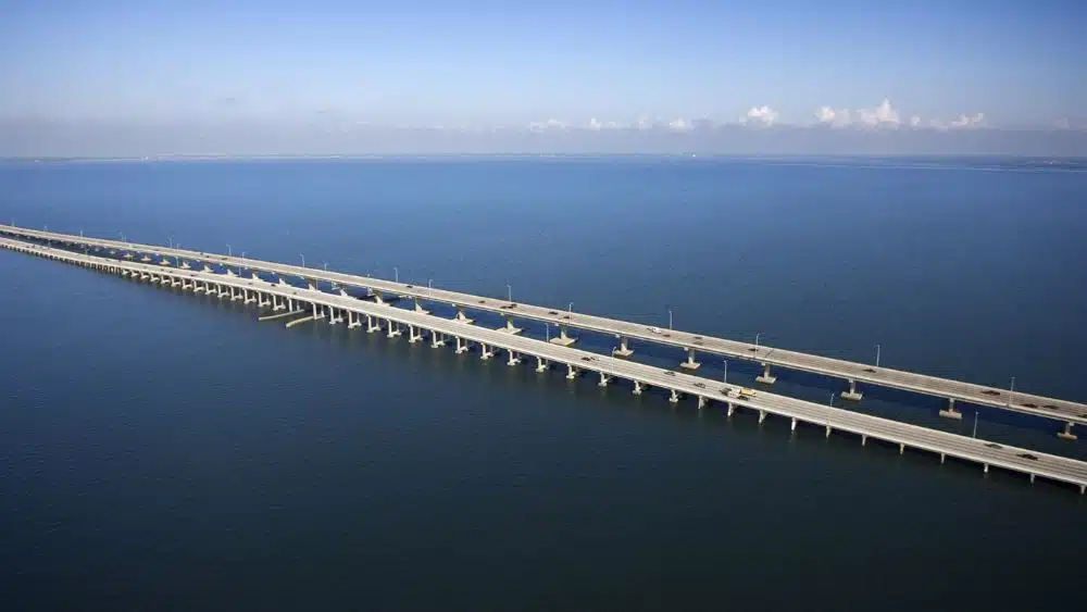 Long four-lane bridge crossing a huge body of water.