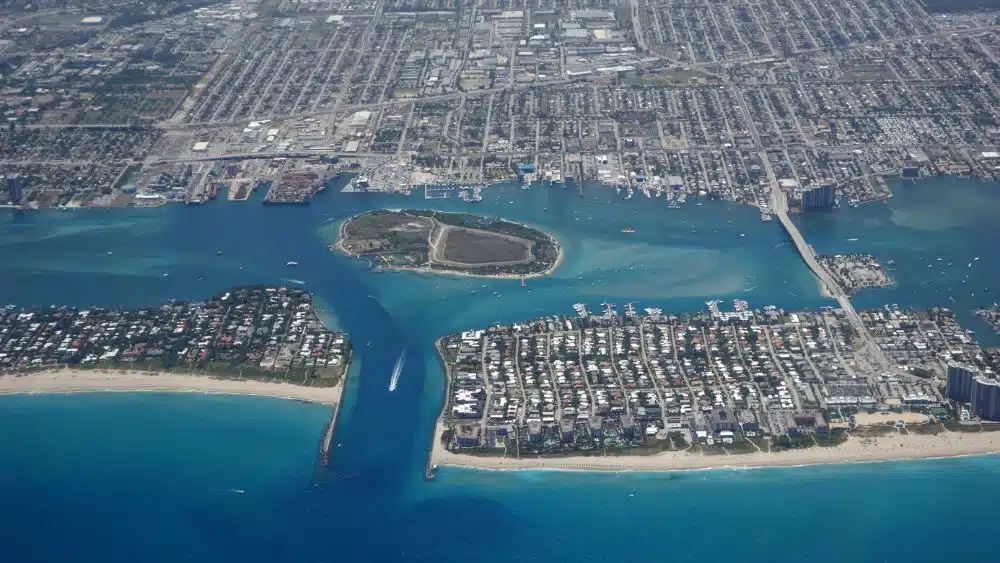 Aerial view of an inlet with an island in the middle. The land is covered with lots of buildings.