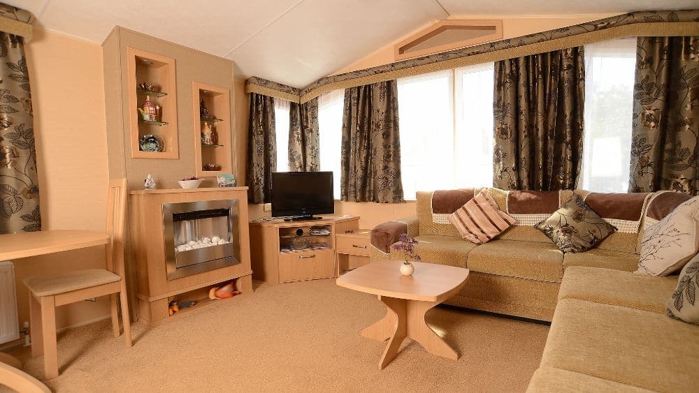 living room in a modular home with beige theme and floral patterned drapes