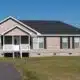 quaint modular home with a covered porch and vinyl siding