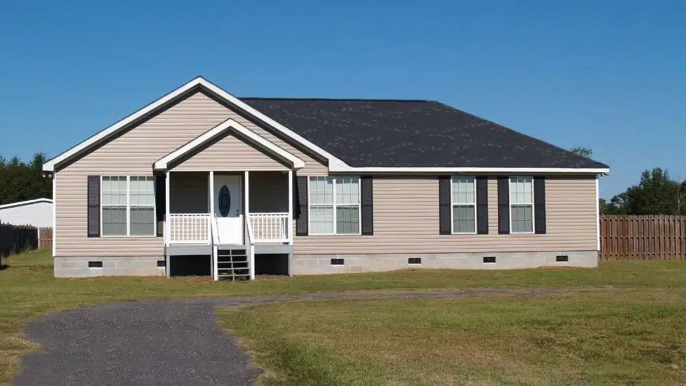 quaint modular home with a covered porch and vinyl siding
