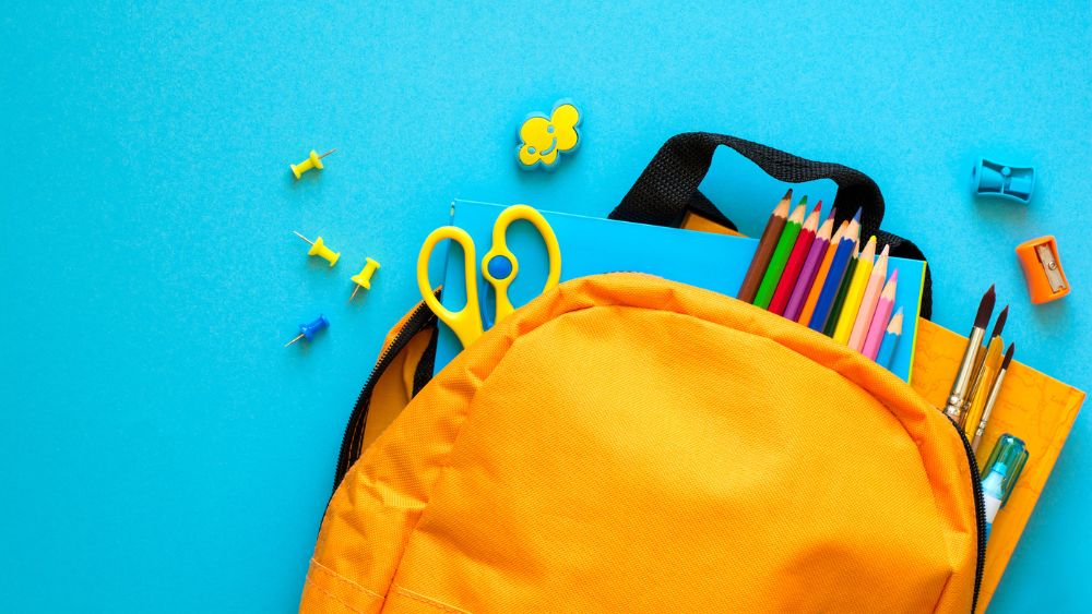 bright orange backpack with school supplies 