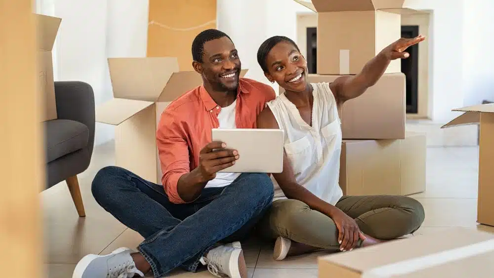 couple sitting on floor with tablet designing new home