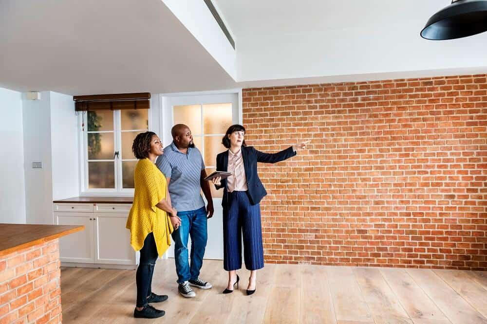 Realtor showing couple a modern industrial home interior